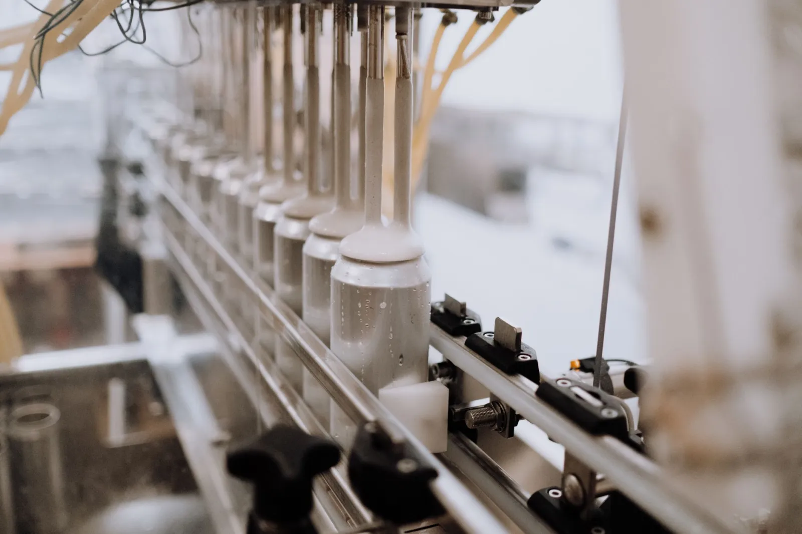 Close-up of automated canning equipment in a brewery, highlighting the manufacturing process.