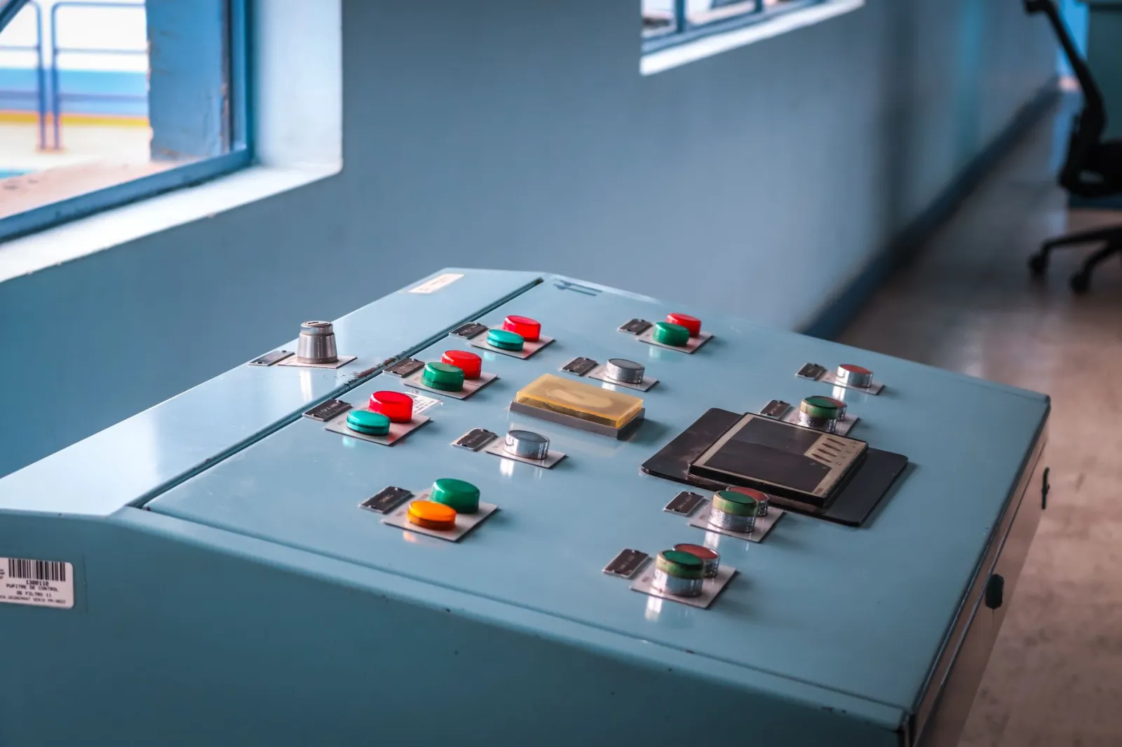 Close-up of an industrial control panel with colorful buttons in a factory setting.